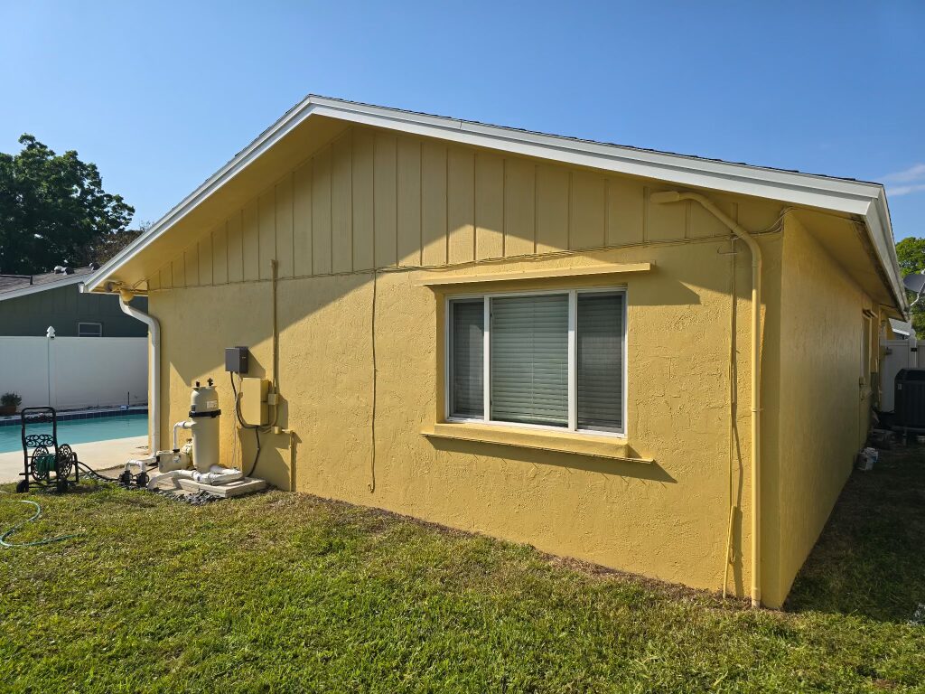 Yellow stucco home exterior with clean white trim